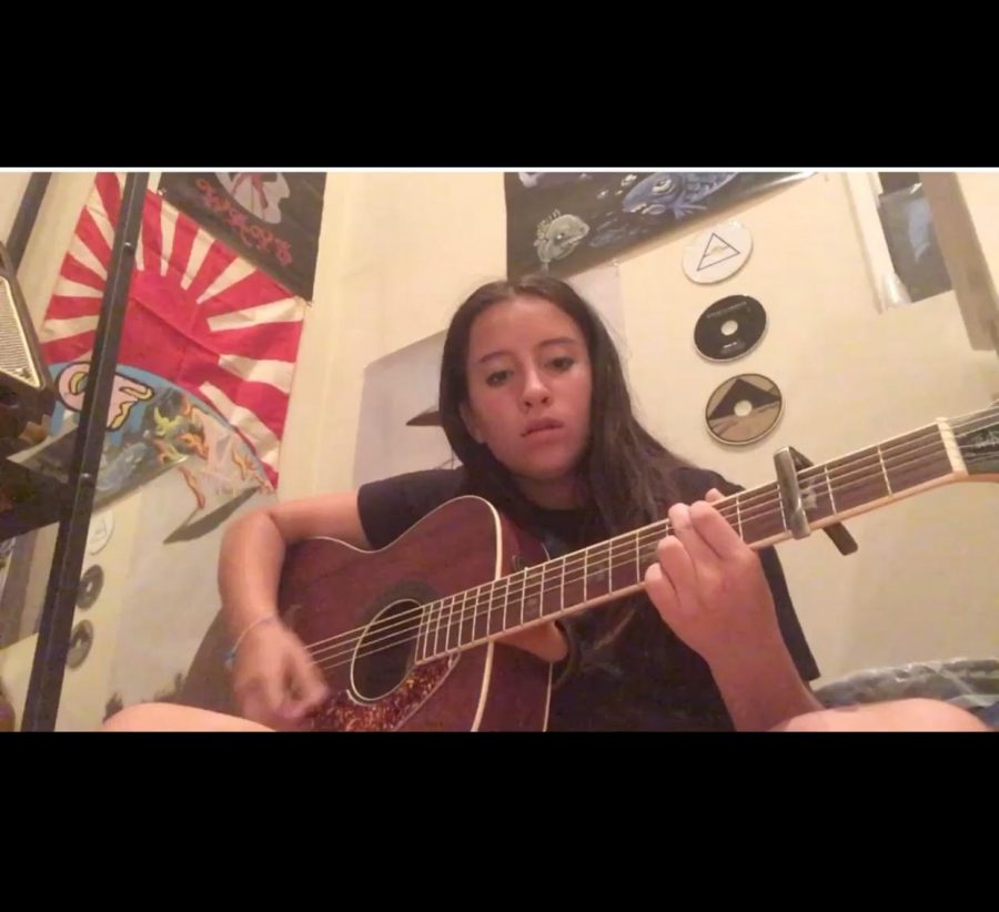 Marlie Machado 23 practicing on her guitar while singing a song she wrote in songwriting. 