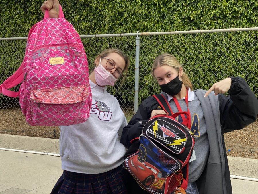 Evelyn LeVecke 22 and Daly Holman 22 hold up their bright pink and Lightning McQueen backpacks. Photo provided by Daly Holman