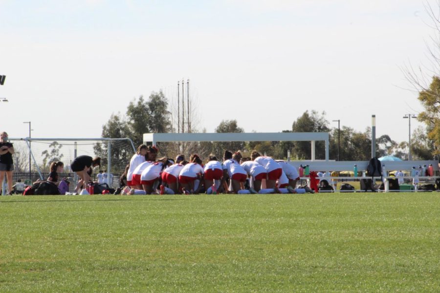 Varsity team praying before one of their Trinity League games.