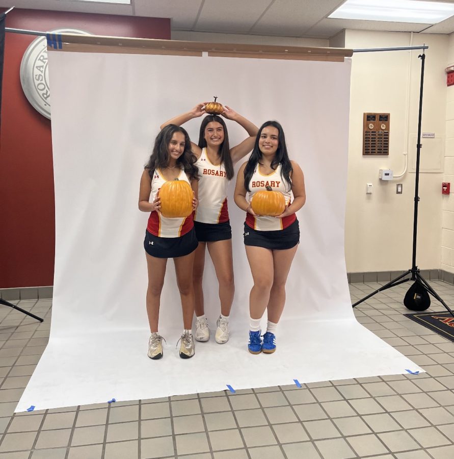 Three varsity tennis players on their media day getting excited for fall. 