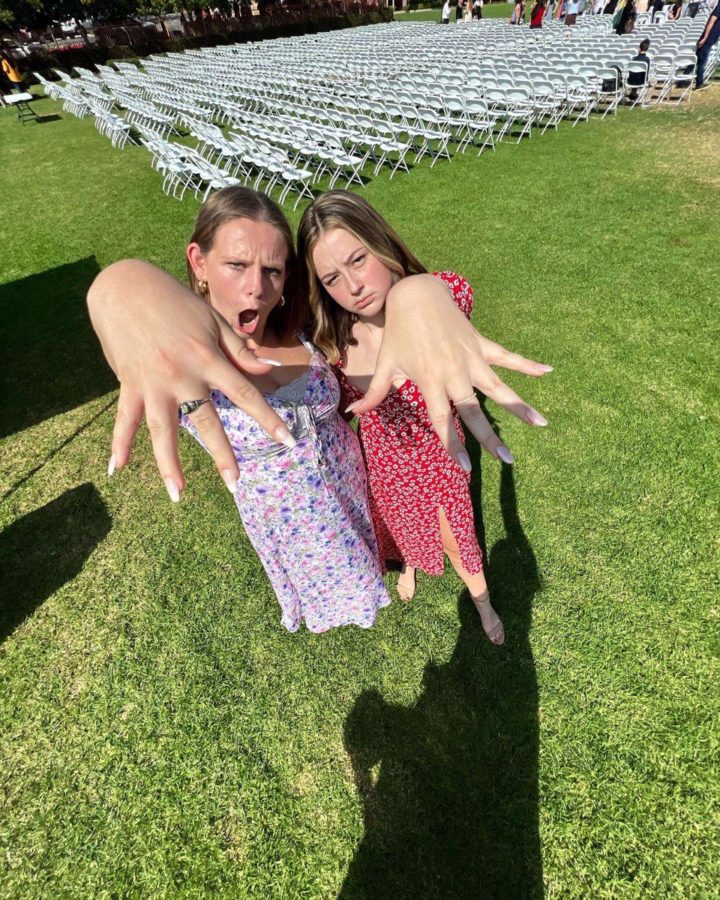 An iconic duo: Finley Hawkins 24 and Claire Heidelman 24 show off their stunning rings and simple floral midi length dresses.