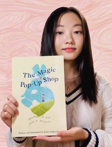 Rosary grad Katie Fang poses with her debut book, The Magic Pop-Up Shop.