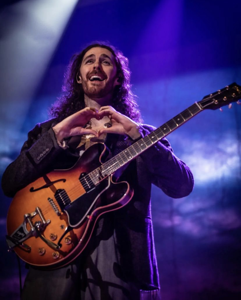 While performing on stage, Hozier shows his love to his fans.