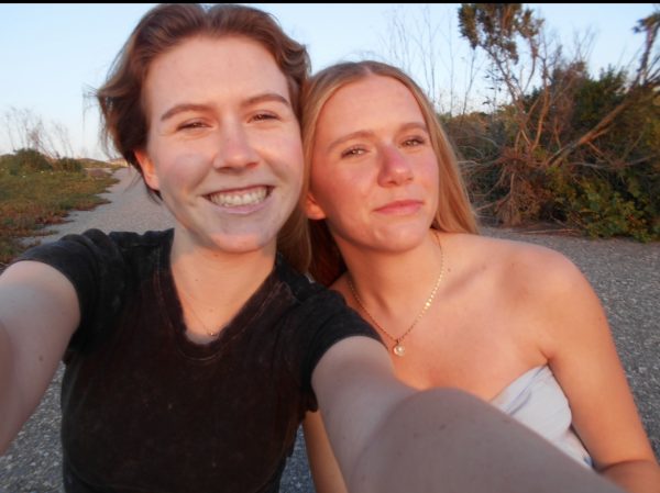 Two sisters enjoy a final beach sunset selfie before graduation.