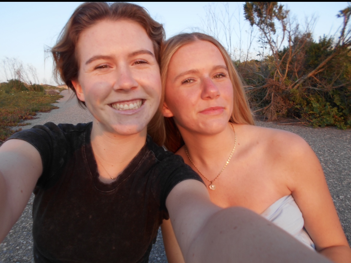 Two+sisters+enjoy+a+final+beach+sunset+selfie+before+graduation.
