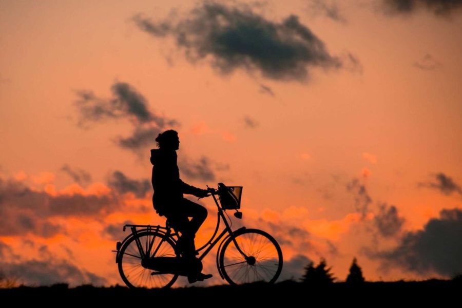 A person riding a bicycle during sunset. Photo via Google under the Creative Commons license