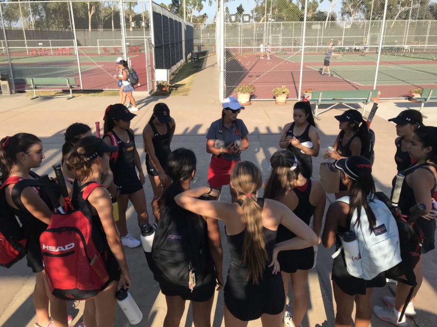 The tennis team listens as Coach Simonton tells them their game plan for the match. Photo credit Tatum Larson.