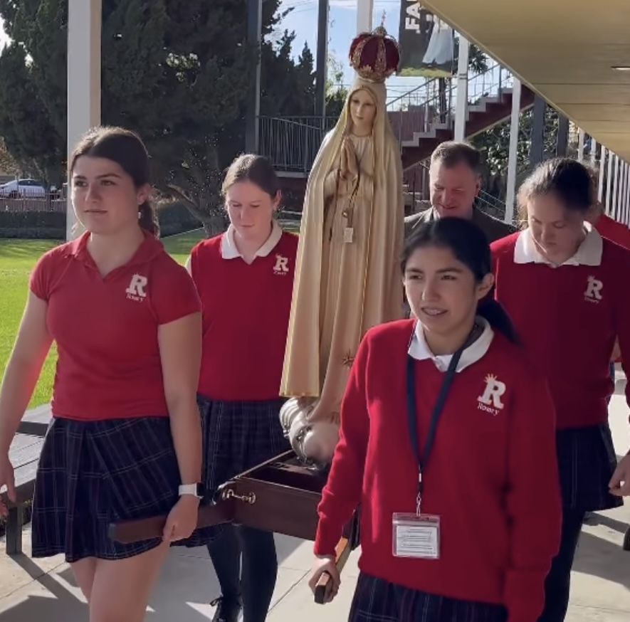 Four campus ministers carry in the statue with reverence. (Photo taken from Instagram @rosaryroyals)