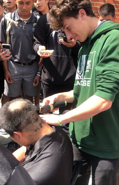 Friars watch as another 
one of their brothers 
gets the friar cut. (Photo Credit: Moises Ibarra)