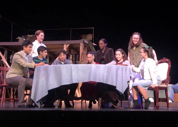 The cast of The Diary of Anne Frank siting at the dinner table.
