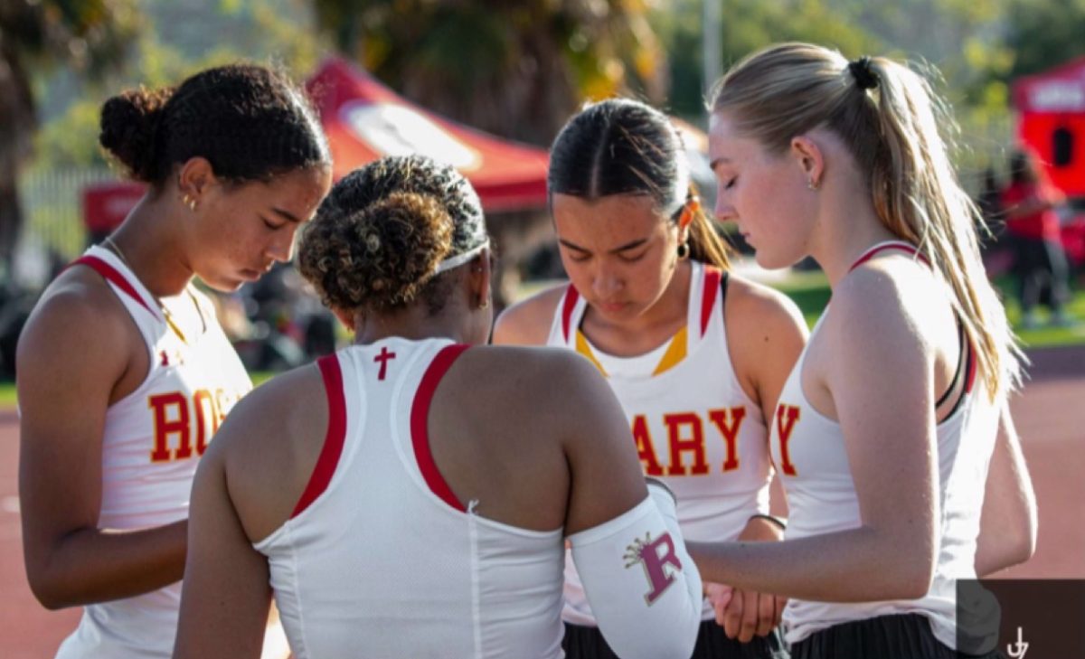 Sophomore Jada Faison prays with seniors Paige Sorensen, Milan Smith, and Elena Saenz before a race. 