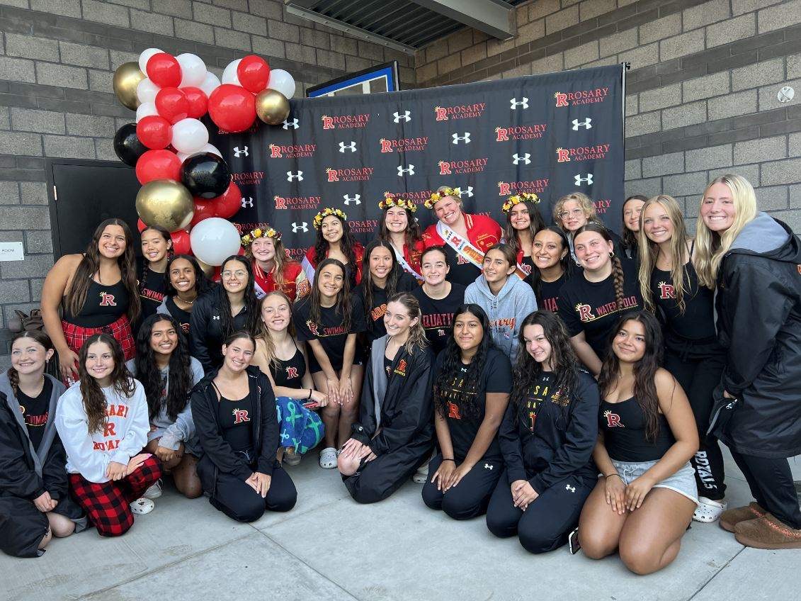 The swim team smiles with the seniors on Senior Night.