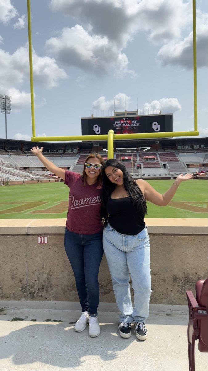 Isabella Solis '25 and her Godmother posing in front of the football field on a formal visit to the University of Oklahoma! 