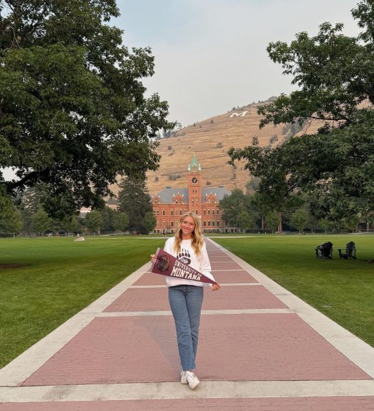 Addison Hansen '26 standing in front of her future college.