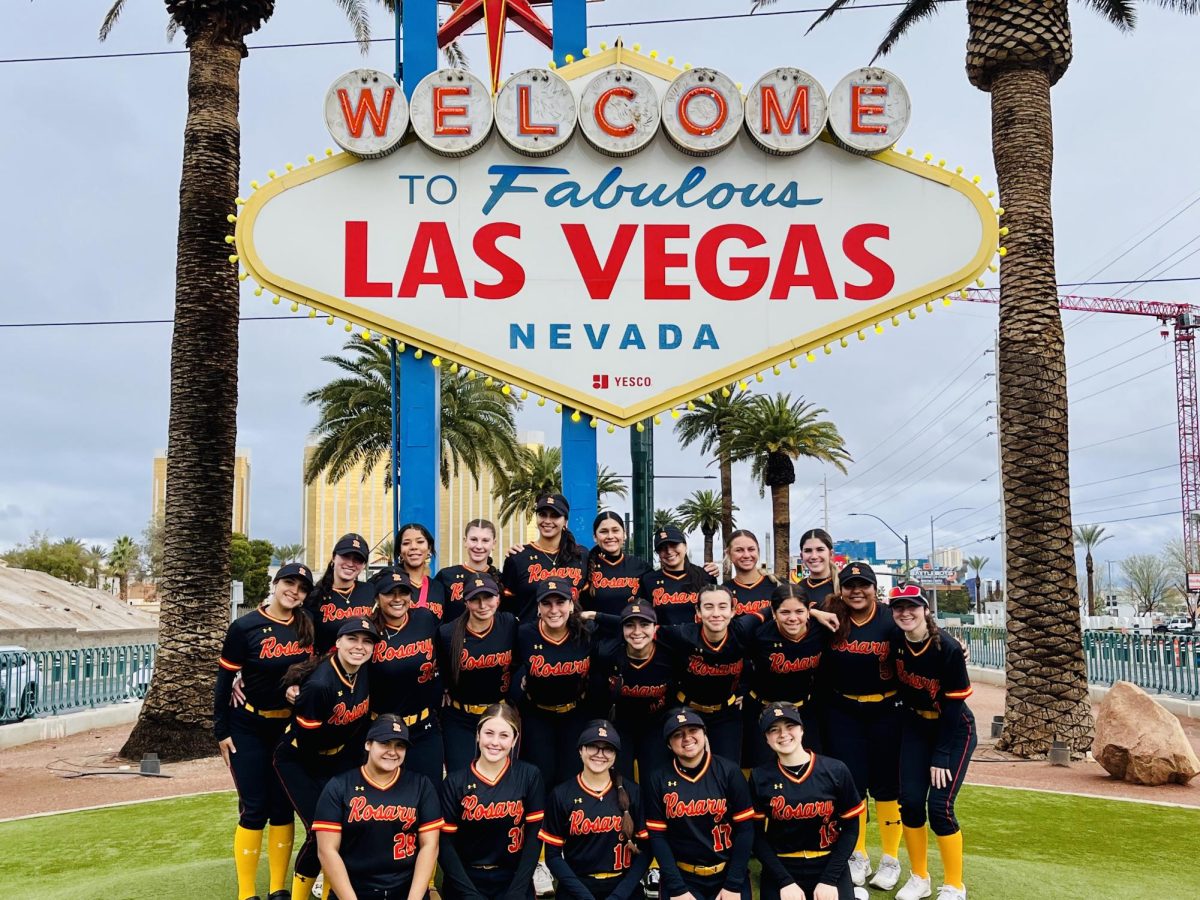 The 2024 varsity softball team smiling in front of the infamous "Welcome to Fabulous Las Vegas" sign.