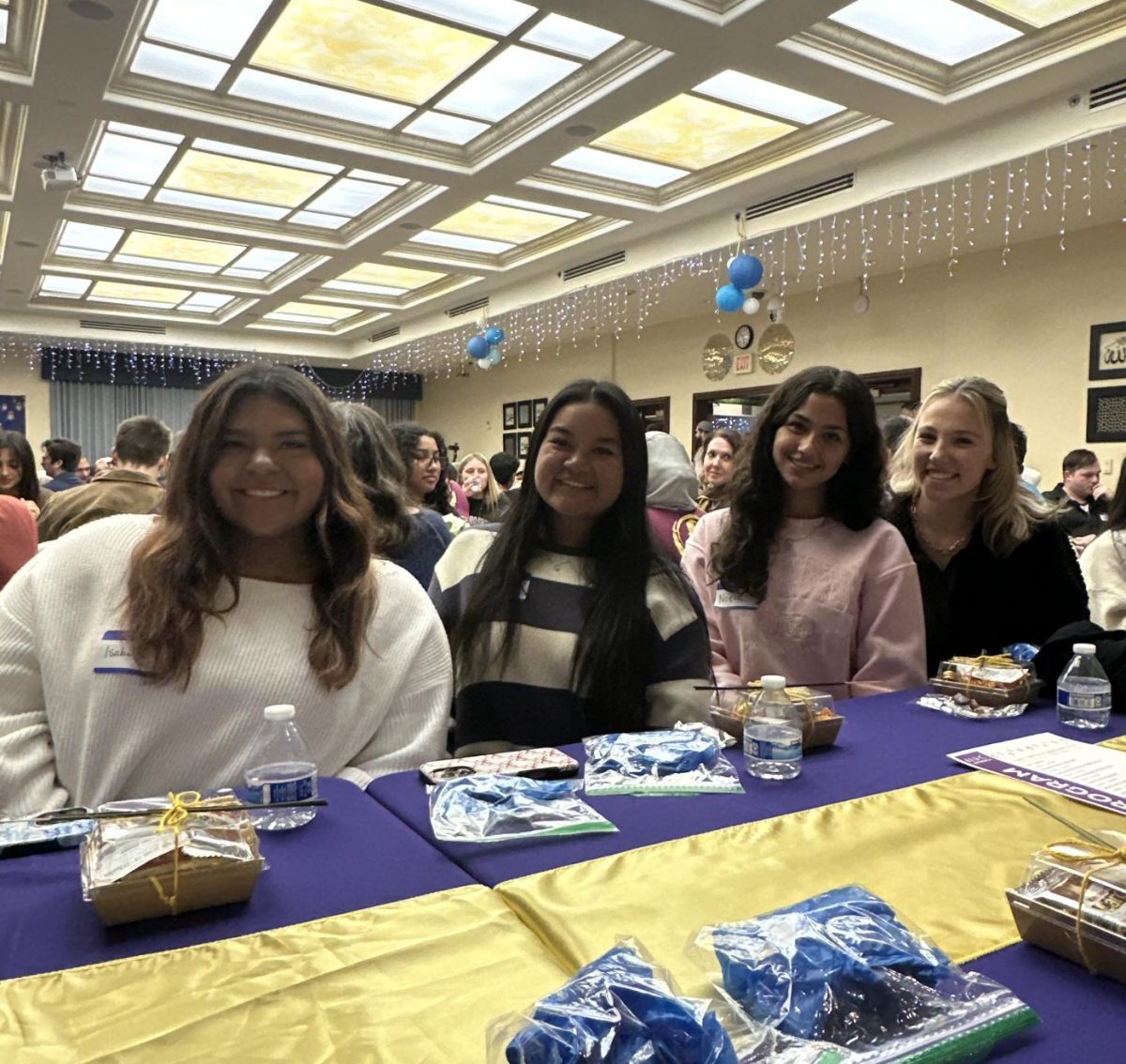 Seniors Bella Contreras, Abby Zabala, Noelle Seibert, and Nikki Green posing for a picture at their table.