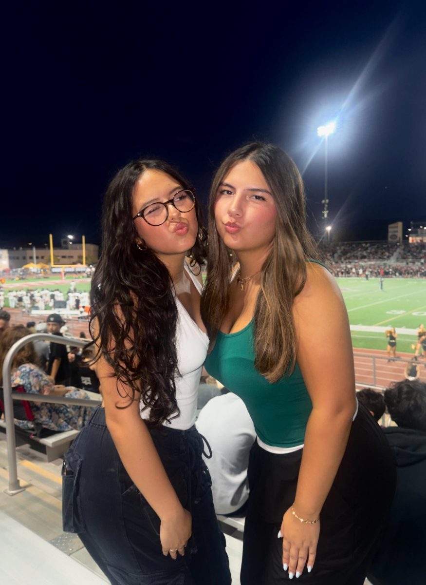 Miabella Baeza '26 and I posing at the game in our green gear!